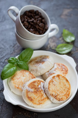 Plate of fried curd pancakes or syrniki with coffee, selective focus