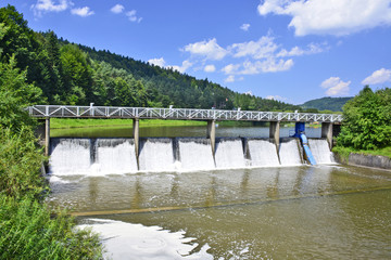 Fototapeta na wymiar Dam on Wisloka river in Krempna village, Low Beskid (Beskid Niski), Poland