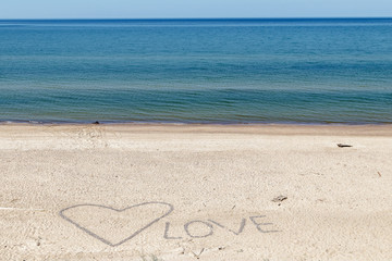 a word LOVE created in sand with stones