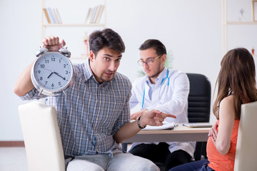 Pregnant woman with her husband visiting the doctor in clinic
