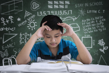 Preteen boy student having headache in classroom