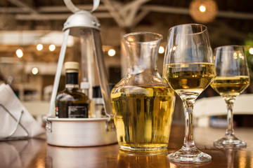 Pouring white wine into the glass against wooden table
