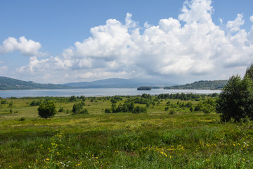 Fototapeta na wymiar Beautiful cloudy sky over the mountain lake. Vlasina lake in eastern Serbia