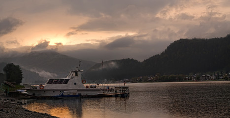 Obraz premium mystical sunset on the lake with boats moored to the bank
