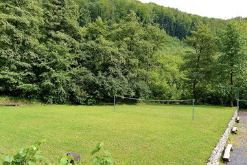 Fototapeta premium stretched between two pillows net for volleyball on a green lawn in the middle of the forest