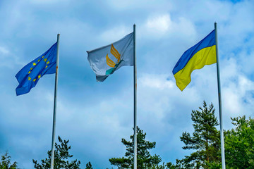 flags of different states fluttering on flagpole against the background of cloudy sky