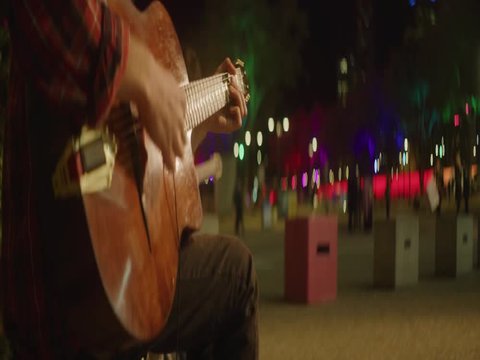 Playing acustic guitar in the streets at night