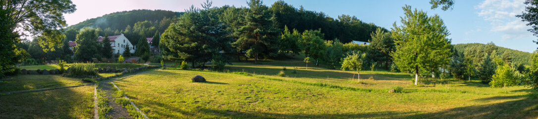 Obraz premium Panoramic view of the garden. In the background, the house is visible
