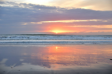 Fototapeta na wymiar Spiegelung im Wasser am Sandstrand in Muriwai Beach