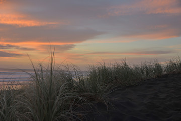Muriwai Beach im Abendrot hinter den Dünen