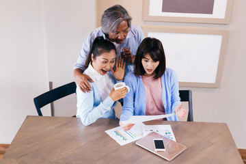 Happy Asian family reading and receiving a good news letter together at home, Information may contain tax refund money, university admission, lottery winning, test results or invitation letter