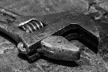 Adjustable wrench on metal table is macro