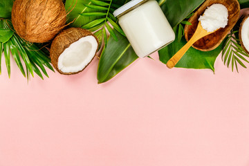 Coconut oil, tropical leaves and fresh coconuts