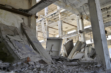 The remains of the destroyed building of a large industrial facility. Background