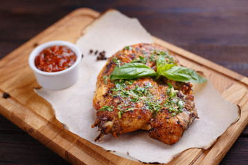 Grilled chicken fillet with tomato sauce and aromatic herbs, appetizing rustic food for meat lovers