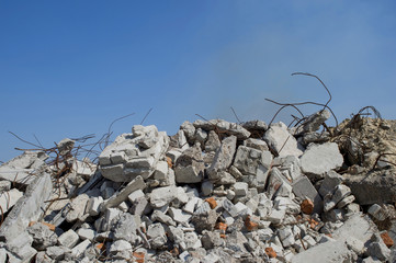 The rebar sticking up from piles of brick rubble. In the background, you can see the remnants of...