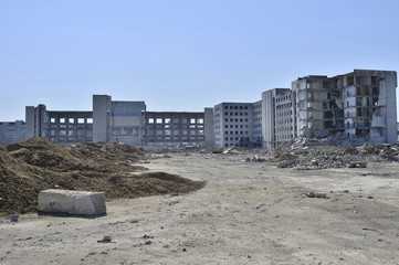 The remains of the destroyed building of a large industrial facility. Background