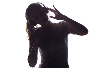 silhouette of woman listening to music in headphones