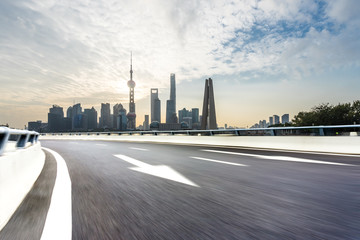 Naklejka premium empty asphalt road with city skyline