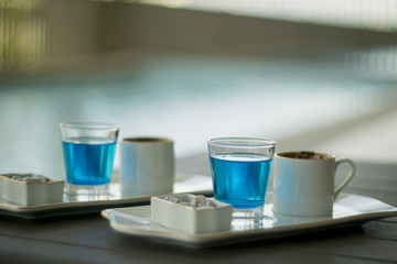 Traditional Oriental nougat with Turkish coffee and blue water on a tray