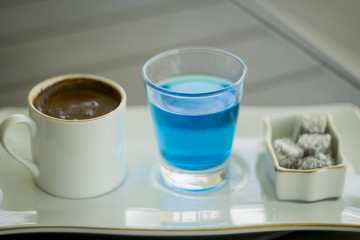 Traditional Oriental nougat with Turkish coffee and blue water on a tray
