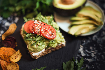 appetizer, bread with avocado and fresh tomato, lettuce, sesame. healthy eating