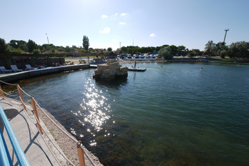 A small pier with large stones at the sea coast with crystal clear water