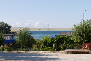 Roadside houses with benches and decorative bushmint blue sea background