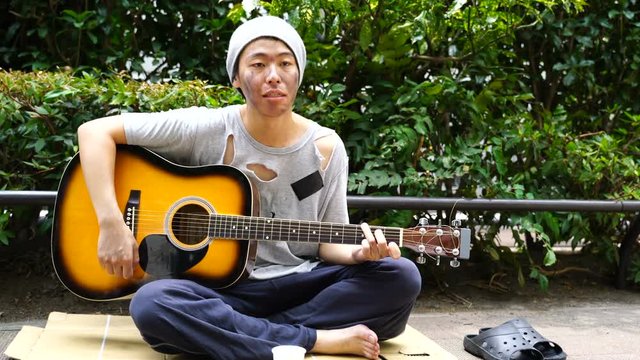 路上生活者・ギターを弾く