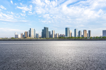 empty asphalt road with city skyline