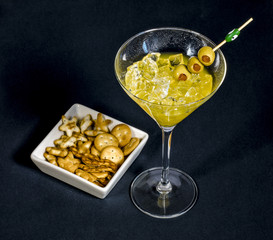 Close-up of cocktail martini with olives on table against