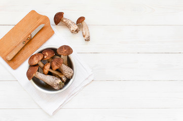Background with autumn mushrooms on the textured white table