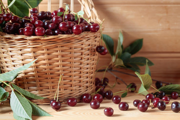 Ripe juicy cherries  in basket on a wooden background.