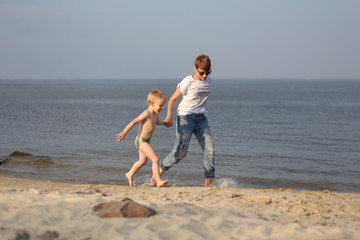 Fototapeta na wymiar Mom son playing sea beach emotions hands