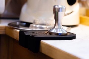 stainless steel tamper.barista equipment.heavy tamper for professional barista brew espresso coffee.close up tamper in coffee shop with space.