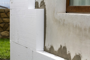 Close-up detail of plastered house wall with rigid styrofoam insulation. Modern technology,...