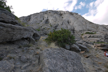 Large rocky rock mountains with small green bushes and trees on them