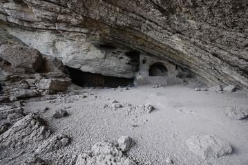 A rocky slope of gray stones under which the beautiful sculptures are cut straight into the rock