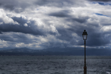 A lonely lantern against the background of the sea and the dramatic sky