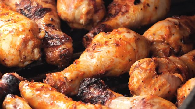 UHD shot of the marinated chicken drumsticks on the grill