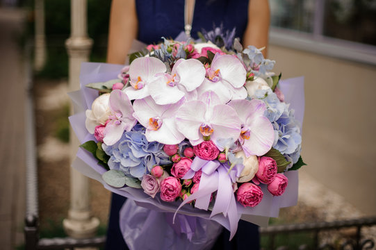 Fototapeta Girl holding bouquet of pastel pink and violet flowers