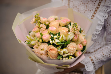 Girl holding bouquet of champagne color pink roses