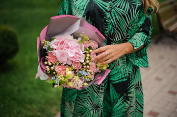 Girl holding bouquet of different pink flowers