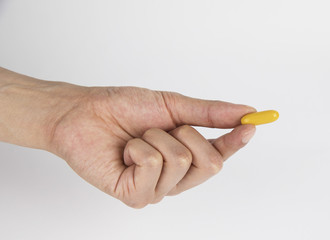 Vitamin And Supplement. Closeup Of Taking Yellow Fish Oil Pill. Hand Putting Omega-3 Capsule. Healthy Eating And Diet Nutrition Concepts. High Resolution Image.