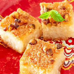 Traditional arabic semolina cake Basbousa or Namoora with nuts and coconut. Close-up. Selective focus. Square photo.