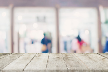 Empty wooden table and Blurred background - Store of shopping mall blur background bokeh with display montage for product.