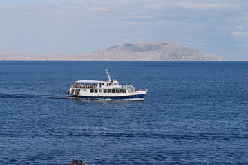 Obraz premium A boat that passes tourists to the other shore through the endless blue sea