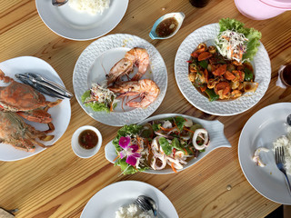 Family or friends in summer party or seafood set dinner. Flat-lay of group of mutinational people at big table eating delicious food together. Summer gathering or celebration. top view background.