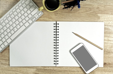 Blank white Paper and smart phone with  black screen and the cup of coffee and office supply for working business communication concept.