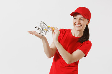 Delivery woman in red uniform isolated on white background. Female courier or dealer in cap, t-shirt, jeans holding supermarket grocery push cart for shopping on palm. Copy space for advertisement.